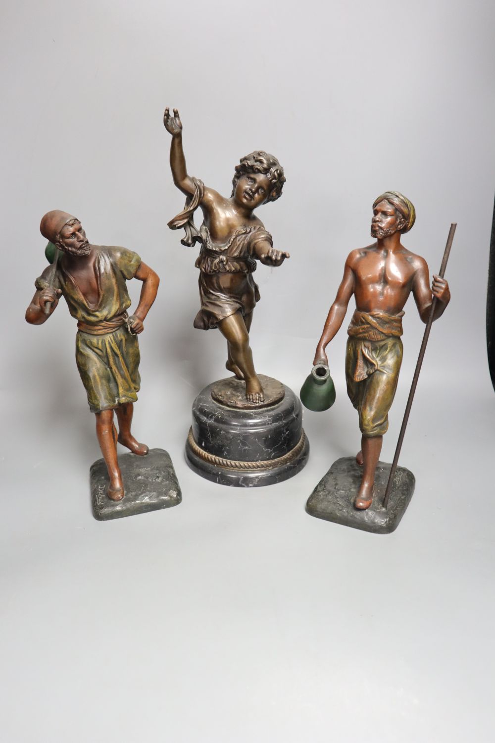 A pair of late 19th century painted bronze labourer figures after Debut, 12in., and a bronze figure of a playful girl, on marble plinth